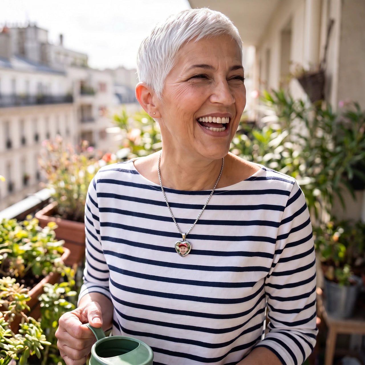 Woman laughing on her balcony, wearing the silver secret heart photo necklace | SKU: TPH-CHTN-SILVER-SMALL